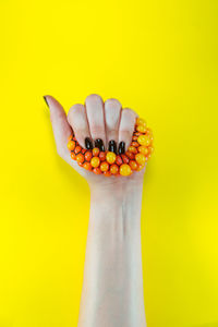 Close-up of hand holding yellow leaf