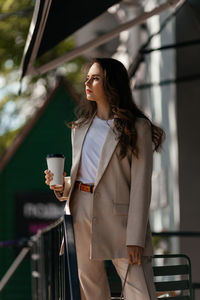 Young woman in white pantsuit and white t-shirt in city location