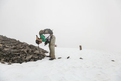 Man puts rocks on snow for navigation, kenai peninsula, alaska