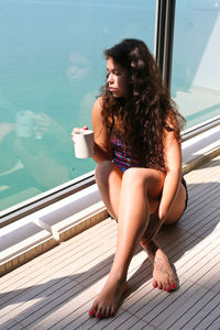 Young woman looking at swimming pool