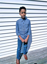 Portrait of teenage boy standing against wall