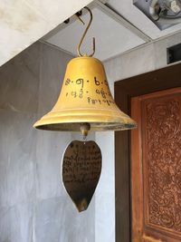 Close-up of electric lamp hanging against wall