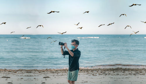 Full length of young man standing on beach