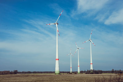 Four wind turbines on field