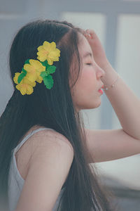 Side view of woman wearing flowers on hair