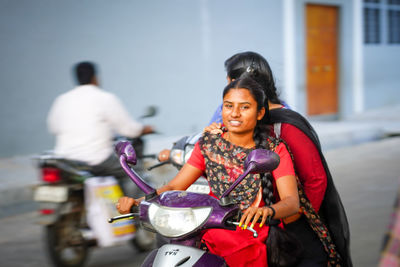 Woman riding motorcycle on street in city