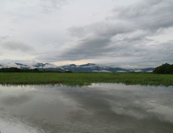 Scenic view of lake against cloudy sky