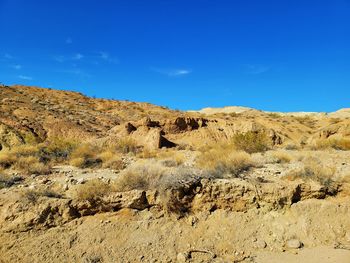 Rock formations on landscape against blue sky