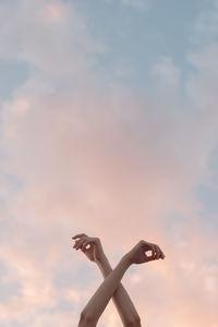 Low angle view of woman hand against sky