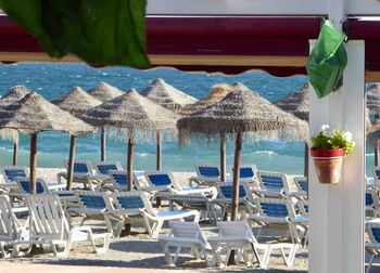 Chairs and table at restaurant by beach