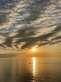 Scenic view of sea and boat against sky during sunset