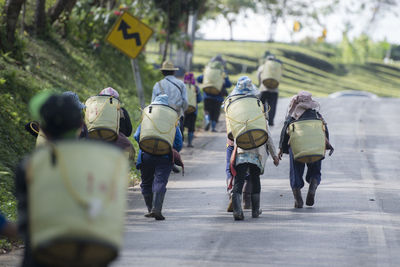 Rear view of people walking on road