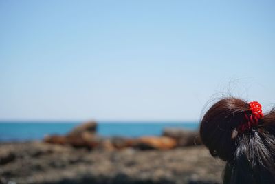 Woman on beach against clear sky