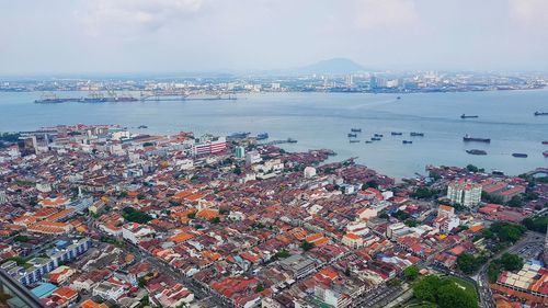 High angle view of city by sea against sky