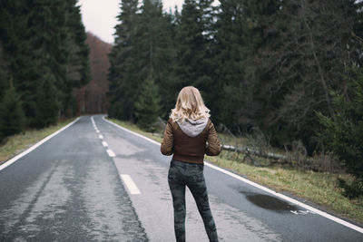 Rear view of woman standing on road