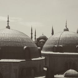 Mosque in city against sky