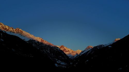 Low angle view of mountains against clear blue sky