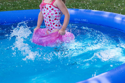 Low angle view of girl playing in swimming pool