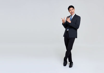 Full length of a smiling young man against white background