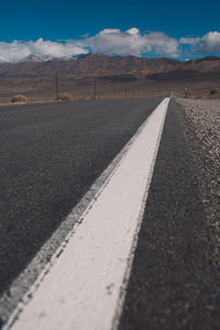 Road by mountains against sky