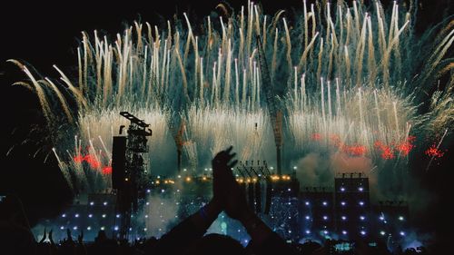 Silhouette woman watching firework display at night