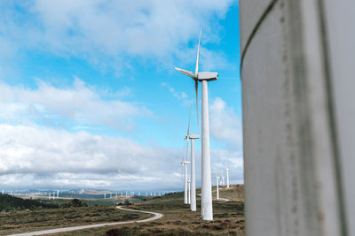 Wind turbines on land against sky