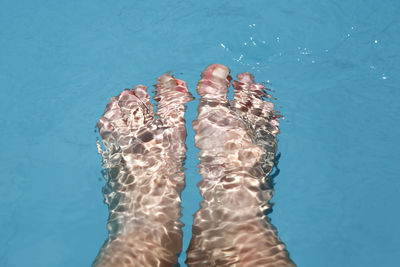 Low section of woman swimming in pool