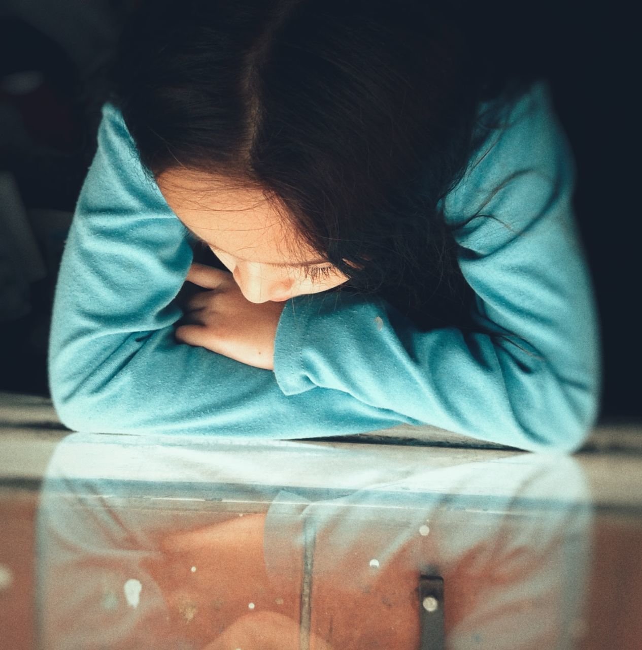 CLOSE-UP OF GIRL SITTING ON BED IN BEDROOM