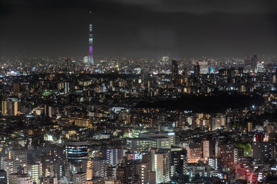 Illuminated cityscape against sky at night