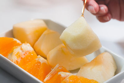 Cropped image of hand holding muskmelon piece