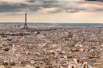 Aerial view of cityscape against cloudy sky