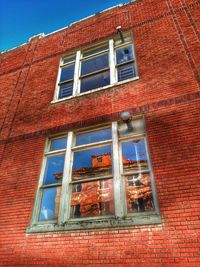 Low angle view of brick wall against blue sky