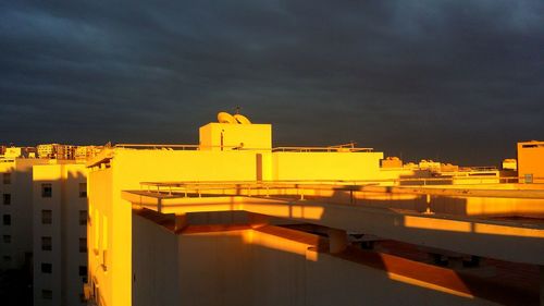 Illuminated buildings against sky at sunset