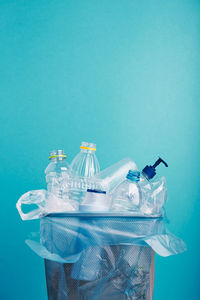 Close-up of bottles in container against blue background