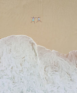 Aerial view of people lying on shore at beach