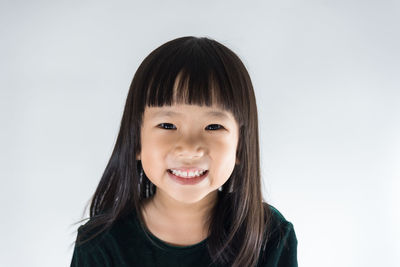 Portrait of a smiling girl against white background