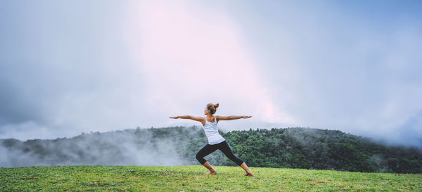 Low angle view of man jumping against sky