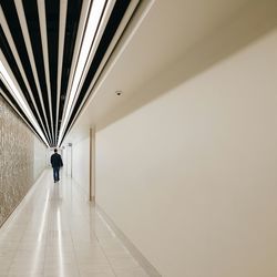 Rear view of man walking in corridor