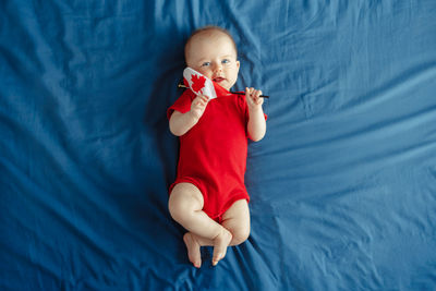 High angle view of cute baby boy on bed