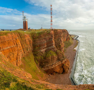 Lighthouse by sea against sky