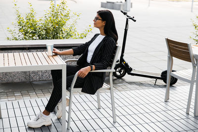 Side view of woman sitting on bench