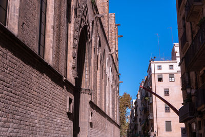 Low angle view of old buildings against blue sky