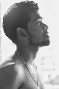 Close-up portrait of shirtless young man