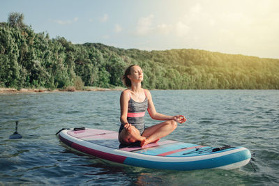 Woman in boat on lake against sky