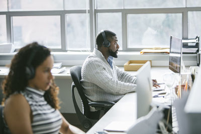 Business people working on desktop computers in office