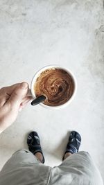 Low section of woman holding coffee