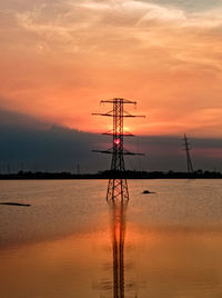 Silhouette crane on sea against sky during sunset