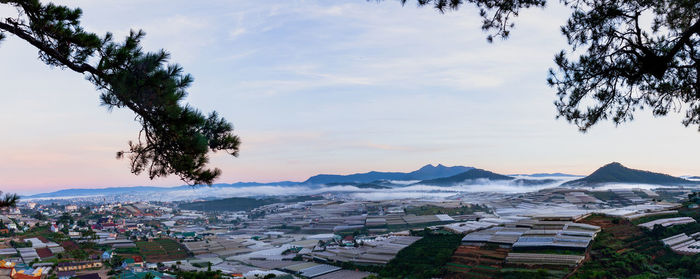 Aerial view of townscape and mountains against sky