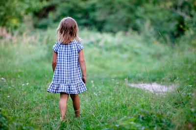 Rear view of girl standing on field