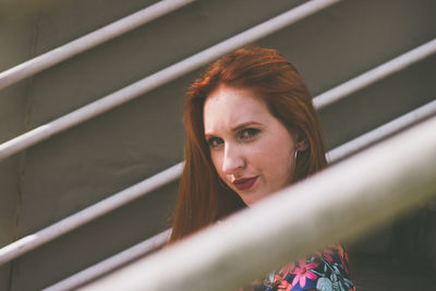 Portrait of young woman amidst railing